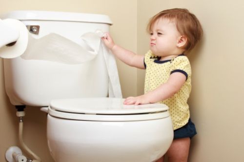 Baby pulling toilet paper off the roll