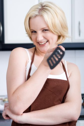 woman holding kitchen utensils in the kitchen