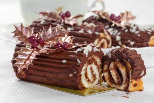 Chocolate roll with the decoration of leaves and berries