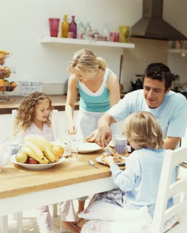 Parents having breakfast with son and daughter (4-6) in kitchen