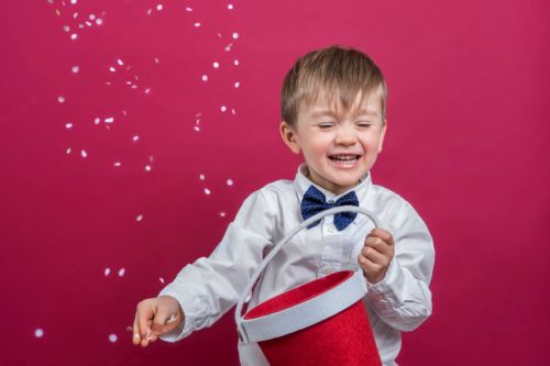 Cheerful boy throwing confetti in the air