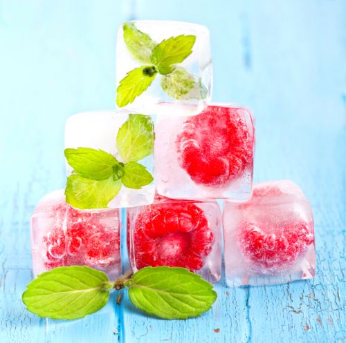 Ice cubes and raspberries with mint leafs